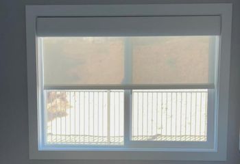 Bright Los Altos kitchen window with custom sheer roller shade partially pulled down, providing filtered daylight and privacy.