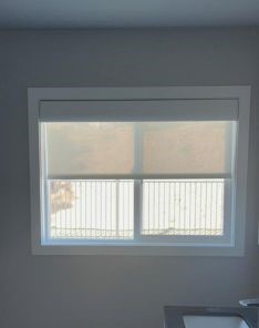 Bright Los Altos kitchen window with custom sheer roller shade partially pulled down, providing filtered daylight and privacy.
